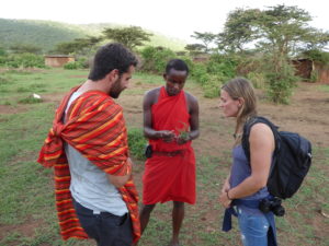 On a walking safari a Maasai guide is explaining different herbs to two visitors.